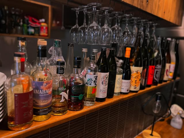 DINING SUNの木製カウンターに並ぶ酒瓶と吊りグラス